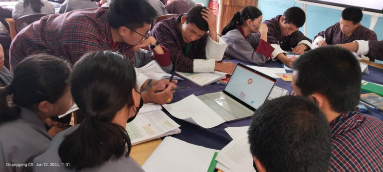 A class session with students sitting in groups.